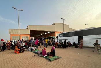 सूडान में संघर्ष से भागे लोग ख़ार्तूम में एक बस अड्डे पर प्रतीक्षा करते हुए.
