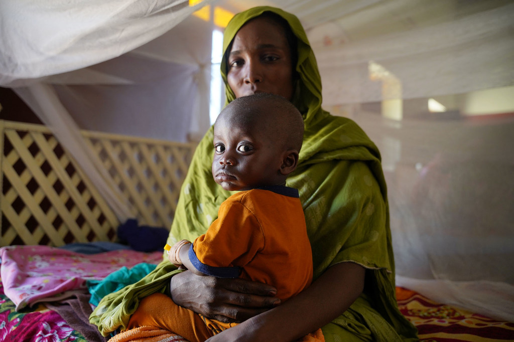 Une mère amène son enfant malade dans un centre de santé soutenu par l'UNICEF dans le nord du Darfour, au Soudan.