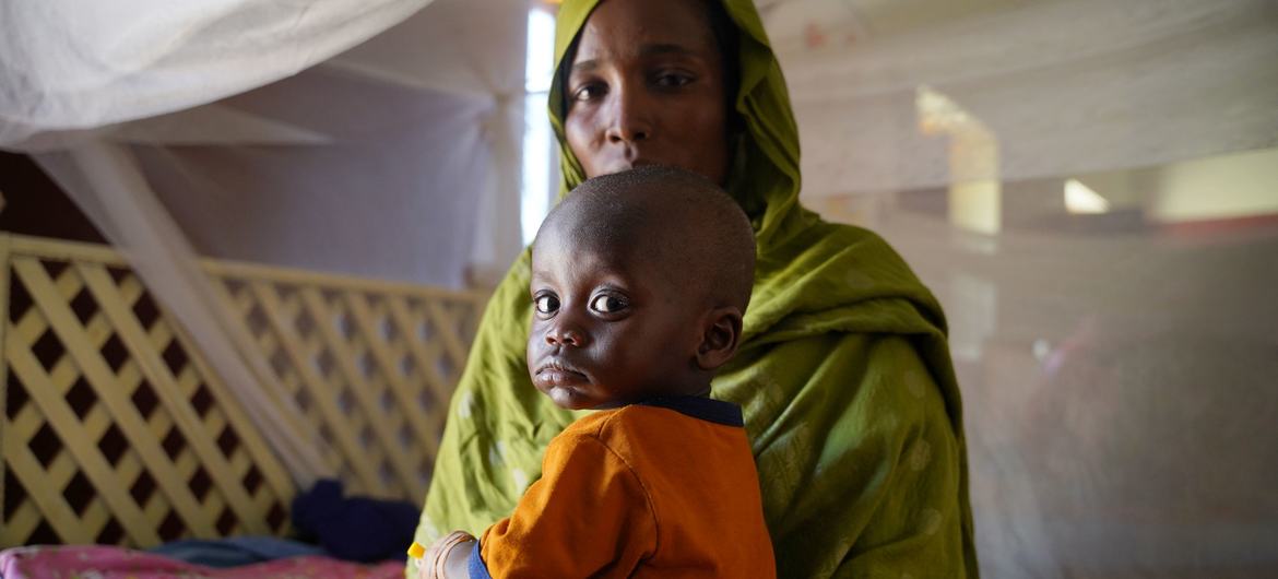 Uma mãe leva seu filho doente a um centro de saúde apoiado pelo Unicef no norte de Darfur, durante o conflito em curso no Sudão