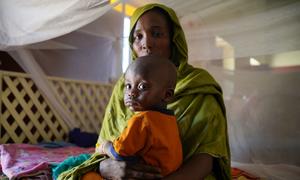 A mother brings her sick child to a UNICEF-supported health centre in Northern Darfur, during the ongoing conflict in Sudan.