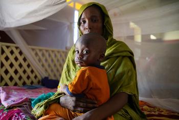 A mother brings her sick child to a UNICEF-supported health centre in Northern Darfur, during the ongoing conflict in Sudan.