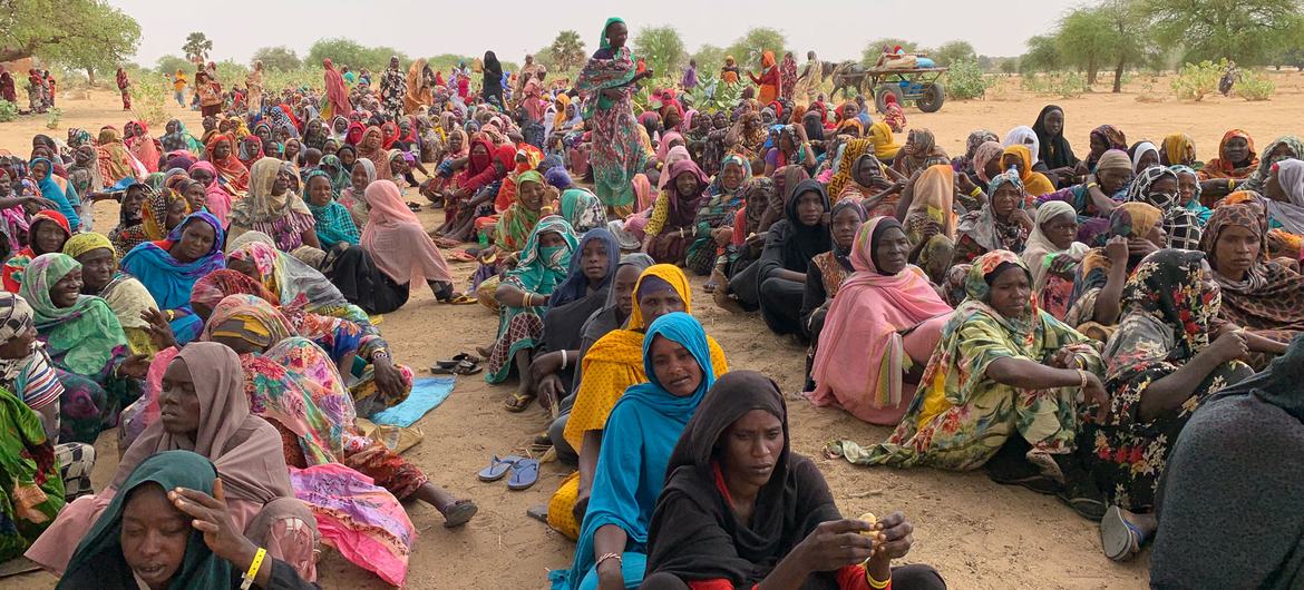 Des réfugiés soudanais attendent de recevoir des produits de première nécessité lors de la distribution à Koufroun, un village tchadien près de la frontière soudanaise.