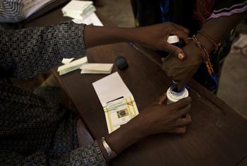 A woman casts her ballot during Mali’s 2013 presidential run-off election in Bamako. The recent dissolution of political parties by the military authorities has raised concerns about the future of democratic participation in the country.