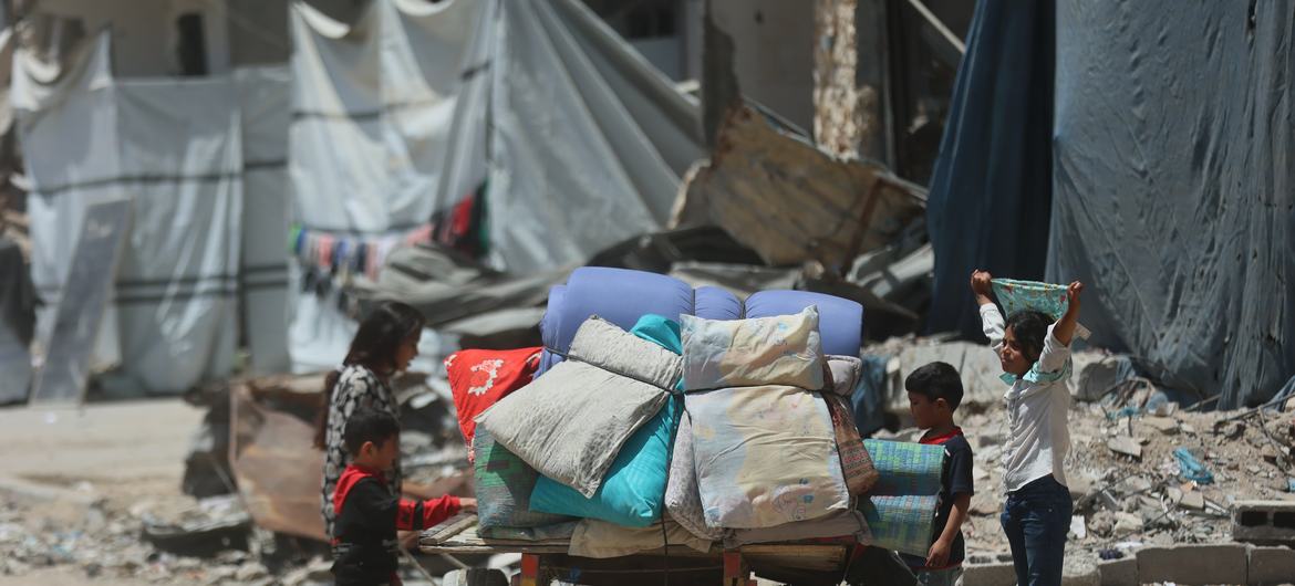 Los hijos de una familia desplazada en la ciudad de Gaza se reúnen en torno a un carro que transporta sus pertenencias.