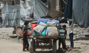  Los hijos de una familia desplazada en la ciudad de Gaza se reúnen en torno a un carro que transporta sus pertenencias.