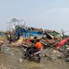在缅甸若开邦首府实兑，几名男子骑着摩托车穿过被气旋破坏的泰昌境内流离失所者营地