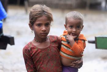 नेपाल के दक्षिणी भाग में, एक लड़की अपने बच्चे भाई को गोद में लिए हुए. उनका परिवार क्षेत्र में भारी बारिश के कारण आई बाढ़ से प्रभावित हुआ था.