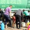 People gather to fill containers with clean water from a UNDP distribution truck in Gaza. Fuel supplies are now critically low, threatening to shut down all aid operations.