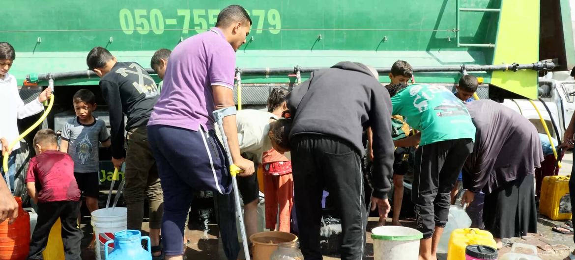 People gather to fill containers with clean water from a UNDP distribution truck in Gaza. Fuel supplies are now critically low, threatening to shut down all aid operations. People gather to fill containers with clean water from a UNDP distribution truck in Gaza. Fuel supplies are now critically low, threatening to shut down all aid operations.