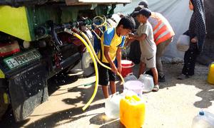 Children collect water from a truck in a displaced persons camp in Gaza. 