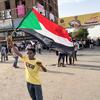 طفل متظاهر يحمل علم السودان في أحد شوارع الخرطوم.