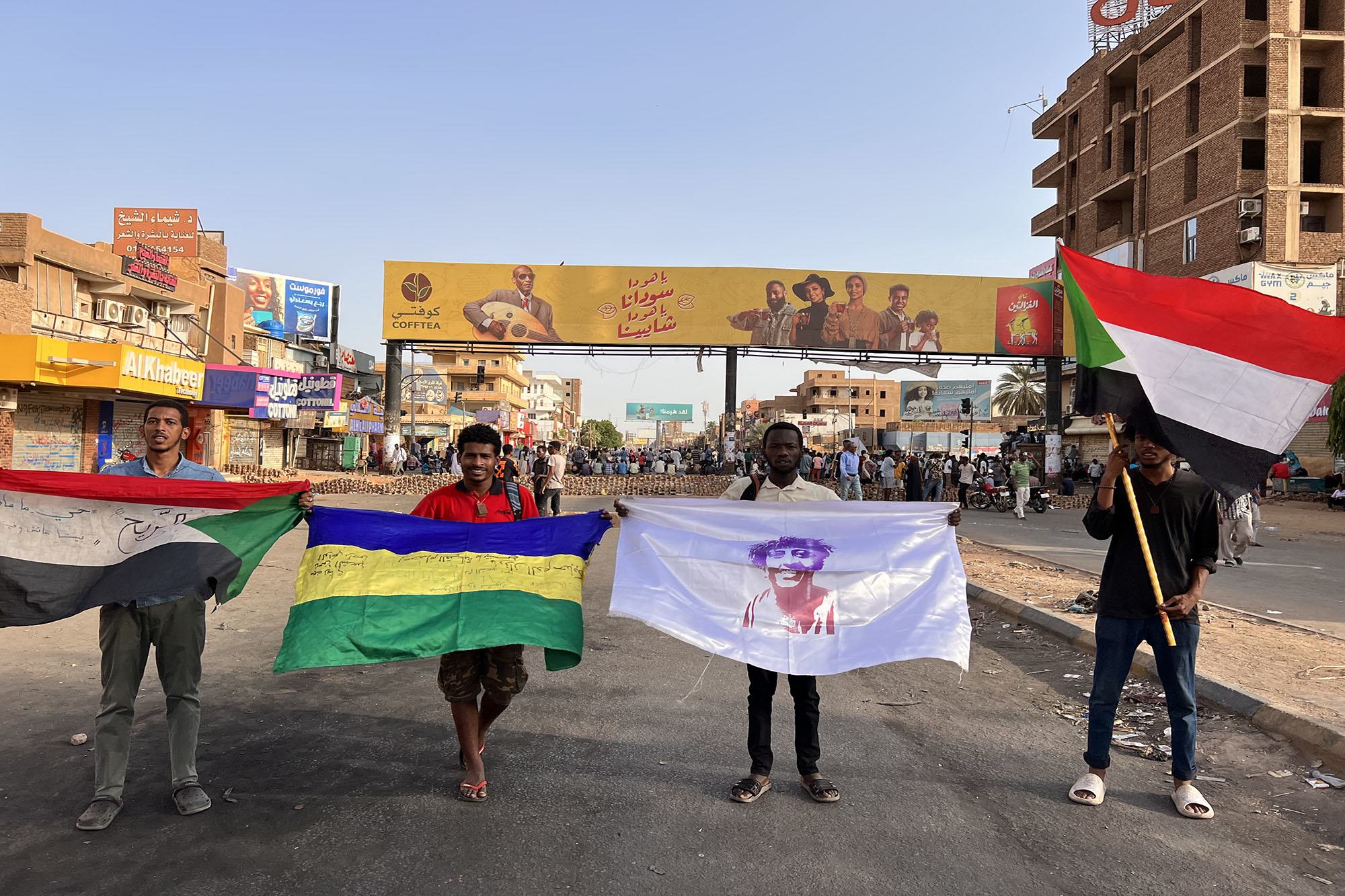 متظاهرون شباب يحملون أعلاما في أحد شوارع العاصمة الخرطوم.