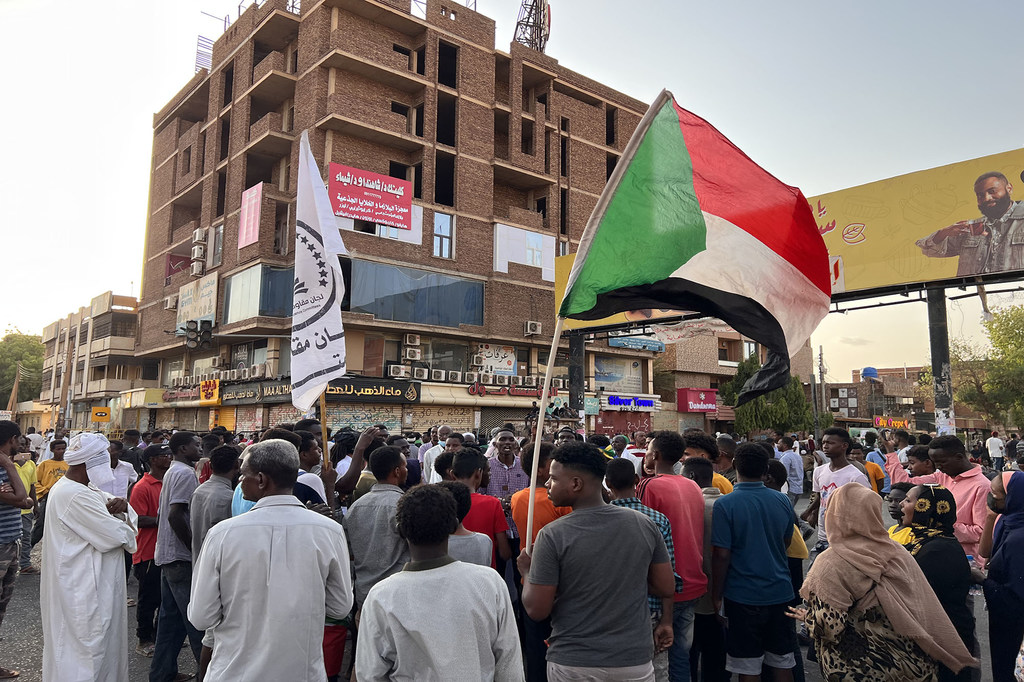 متظاهرون يحملون العلم السوداني في شارع المؤسسة في الخرطوم بحري، السودان.