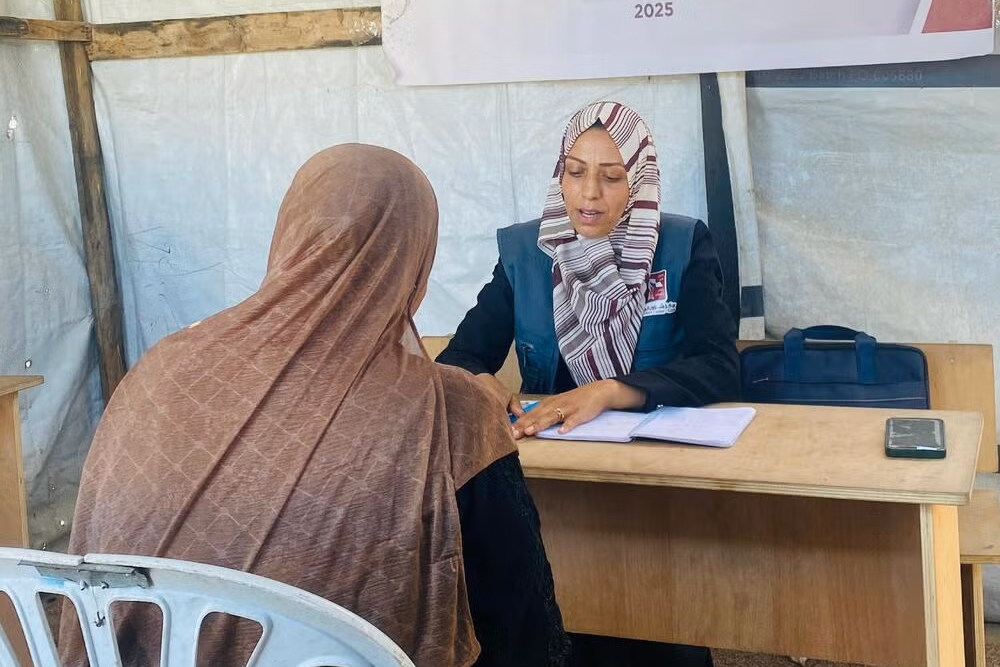 تتحدث أمل مع سيدة في مركز شؤون المرأة الذي يدعمه صندوق الأمم المتحدة للسكان في مخيم البريج للاجئين.