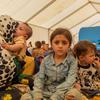 A five-year-old girl sits with her mother and siblings in a tent at the Islam Qala border crossing. The Afghan family of eight has now returned to Afghanistan after previously leaving for Iran because of economic hardship at home.