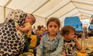 A five-year-old girl sits with her mother and siblings in a tent at the Islam Qala border crossing. The Afghan family of eight has now returned to Afghanistan after previously leaving for Iran because of economic hardship at home.
