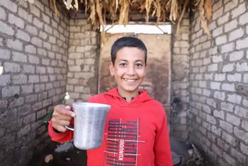 يمسك محمد أول كوب ماء يصل إلى منزلهم.