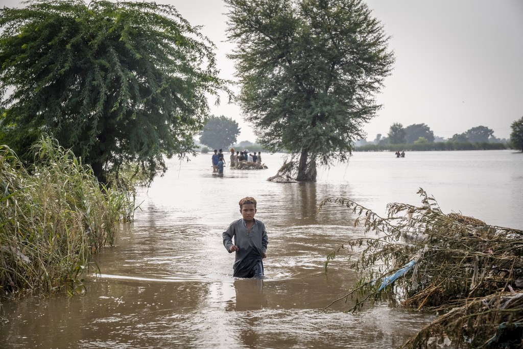 Un enfant de sept ans traverse les eaux de crue jusqu’à la taille dans le Pendjab, la province la plus peuplée et la plus touchée du Pakistan.