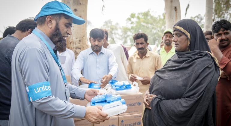 पंजाब के झंग ज़िले में यूनीसेफ़ का एक कर्मचारी बाढ़ प्रभावित परिवारों को स्वच्छता किट और पानी शुद्ध करने की गोलियाँ बाँट रहा है.