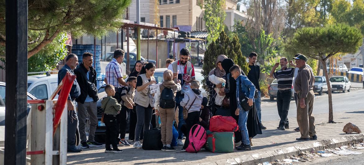 Displaced families wait to cross border from Lebanon into Syria. 