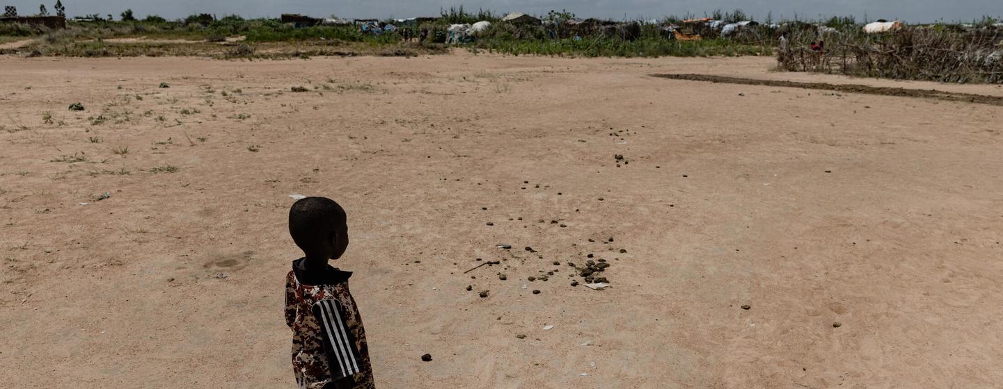 کودکی با آب جمع آوری شده از کمپ آوارگان در نیالا، دارفور ایستاده است.  (فایل)