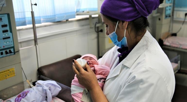 काबुल के मलालाई मातृत्व अस्पताल में, मुख्य दाई एक नवजात शिशु की देखभाल करते हुए.