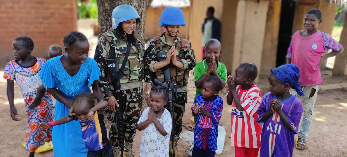 In conflict zones, female peacekeepers play an important role in building trust with local people. In the photo, female peacekeepers from Nepal are joined by women and children from local communities in the Central African Republic..