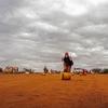 Une jeune fille déplace un conteneur rempli d'eau sur un site pour personnes déplacées à Dolow, en Somalie.