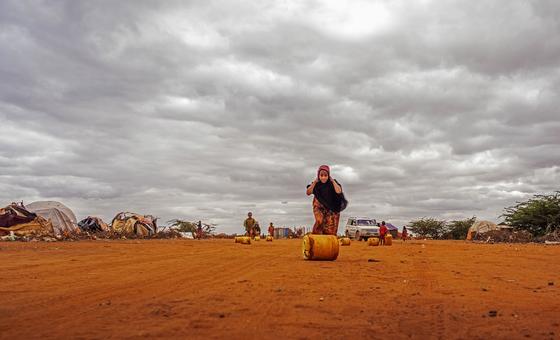 A girl moves a container full of water at a site for displaced people in Dolow, Somalia.