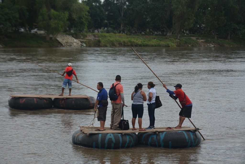Un grupo de personas cruzando el río Suchiate en una balsa en la frontera de Chiapas con Guatemala, México, en noviembre de 2021.