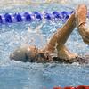 La nadadora Maggie Leri realiza una brazada de estilo libre en una piscina durante una competición de natación.