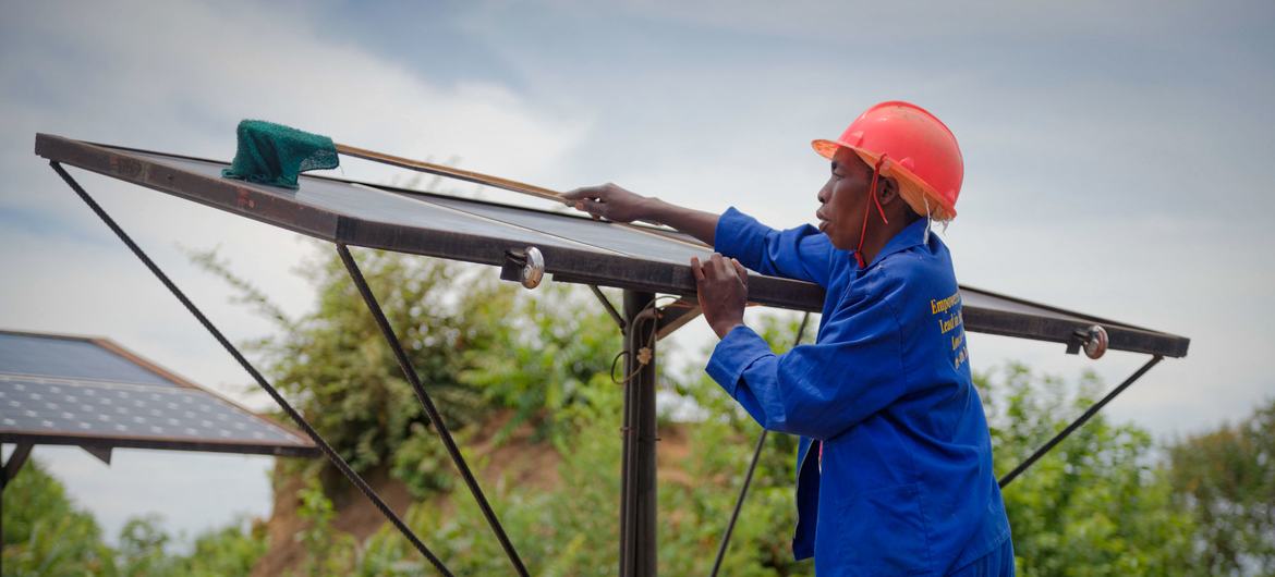 Рабочий устанавливает солнечную батарею в сельскохозяйственном кооперативе в Замбии.