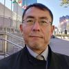 Tomoya Obokata, Relator Especial sobre formas contemporâneas de escravidão, posa para um retrato em frente a um prédio com bandeiras nas Nações Unidas, em Genebra.