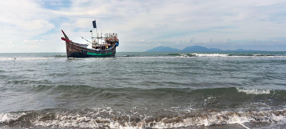 A boat that carried Rohingya refugees across the Andaman Sea remains anchored offshore after the refugees disembarked at a beach in Aceh, Indonesia on 8 January, 2023.