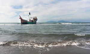 2023年1月8日，穿越安达曼海而来的罗兴亚难民在印度尼西亚的亚齐特区上岸，他们搭乘的船只仍停靠在海边。
