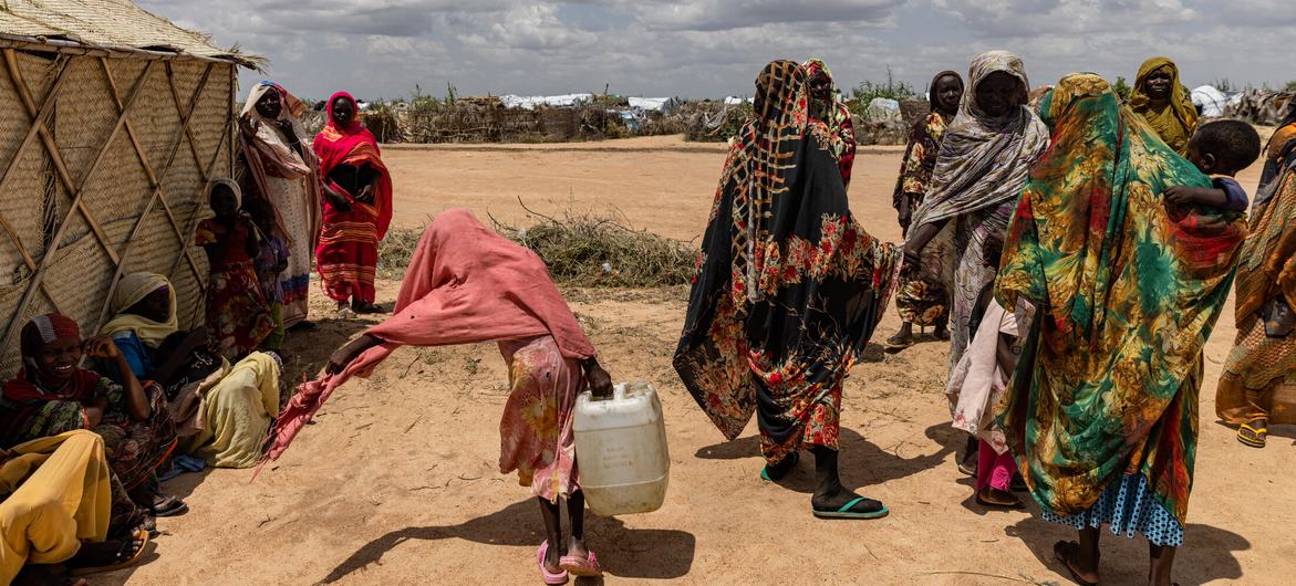 سوڈان میں بے گھر افراد کے ایک کیمپ میں خواتین اور لڑکیاں پینے کے لیے پانی لا رہی ہیں۔