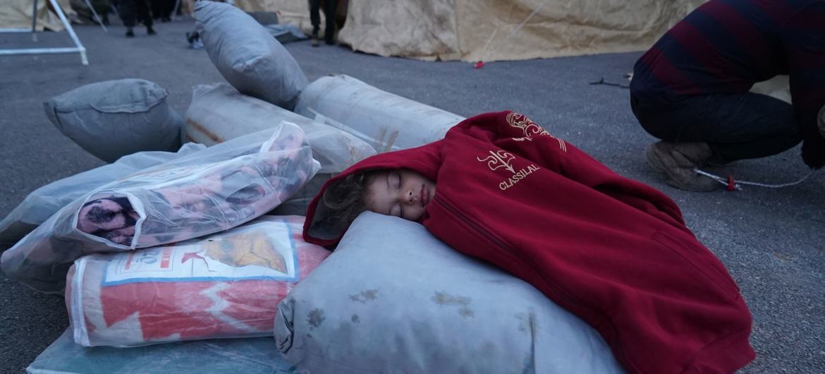 طفل ينام على مواد إغاثية في أحد مراكز الاستقبال في بلدة الجنديريس شمال سوريا.