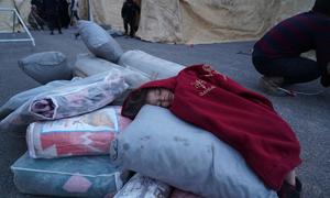 A child sleeps on relief items at a reception centre in Jandairis town in northern Syria.