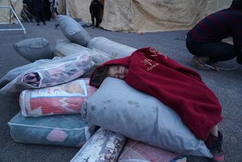 طفلة تنام فوق مواد إغاثية في أحد مراكز الاستقبال في بلدة جنديريس شمال سوريا.