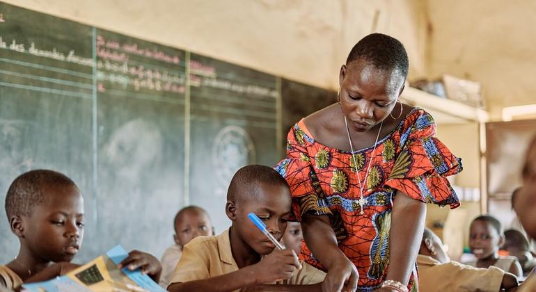 Sophia Sokoka, profesora de la escuela primaria pública de Tchoutchoubou, en Benín, ayuda a Abasse Dahani con sus deberes escolares. Abasse es un refugiado de Burkina Faso