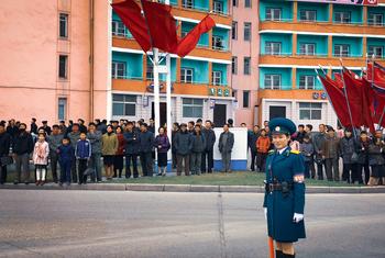 Residents of Pyongyang, DPRK, wait to cross the road.
