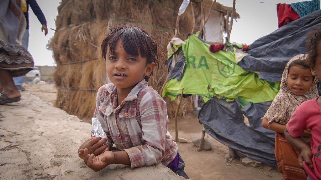 Un jeune garçon joue pendant que sa mère fait la queue à un point d'eau dans un camp de déplacés à Aden (photo d'archives).