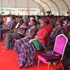 Watazamaji katika tukio nchini Uganda, wakiwa wameketi kwa safu kwenye zulia jekundu chini ya hema.