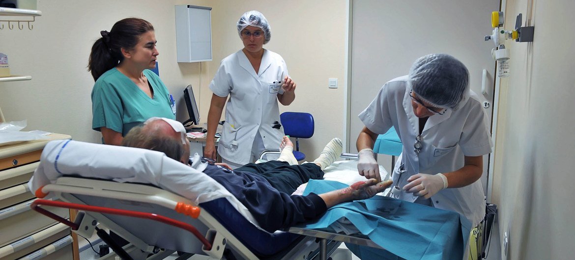 أخصائيون طبيون يعتنون بمريض مصاب على نقالة في المستشفى.