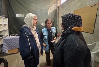Yasmina Guerda, oficial de asuntos humanitarios de la ONU (centro), habla con una mujer palestina en Rafah, Gaza, en marzo de 2024.