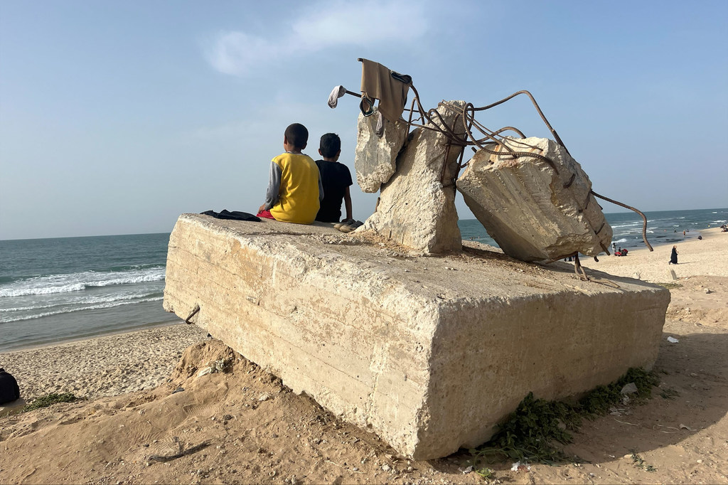 Deux garçons regardent l'océan sur une plage, à Rafah, Gaza, avril 2024.