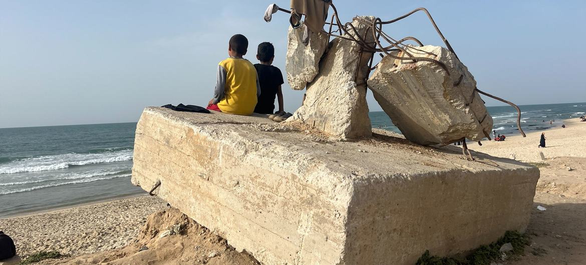 Two boys gaze out at the ocean at a beach, in Rafah, Gaza, April 2024.