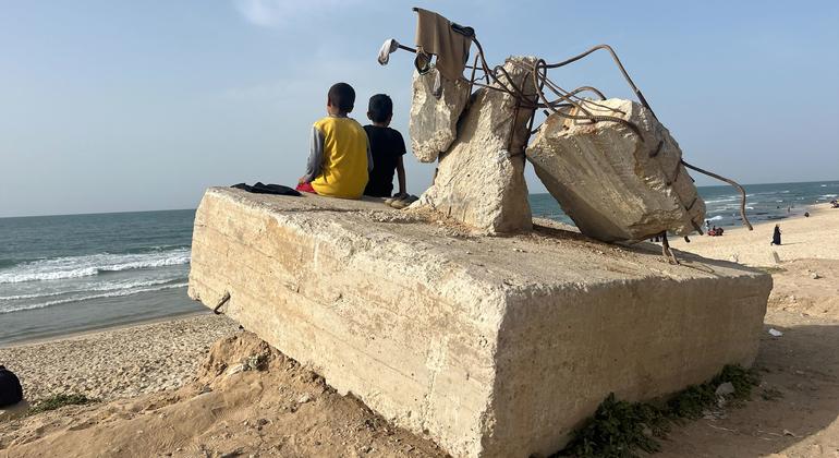 طفلان فلسطينيان يجلسان على كتلة خرسانية على الشاطئ بمدينة رفح، جنوب غزة.