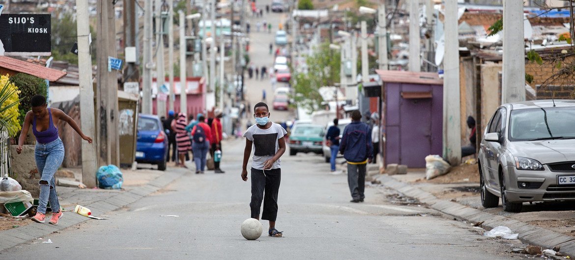 A man kicks a soccer ball up the street during lockdown in Alexandra Township, Johannesburg, 3 April 2020.