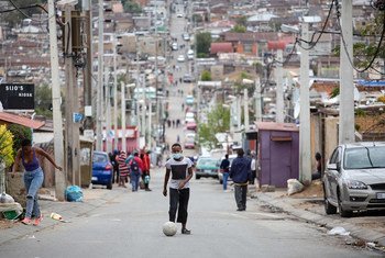 A man kicks a soccer ball up the street during lockdown in Alexandra Township, Johannesburg, 3 April 2020.